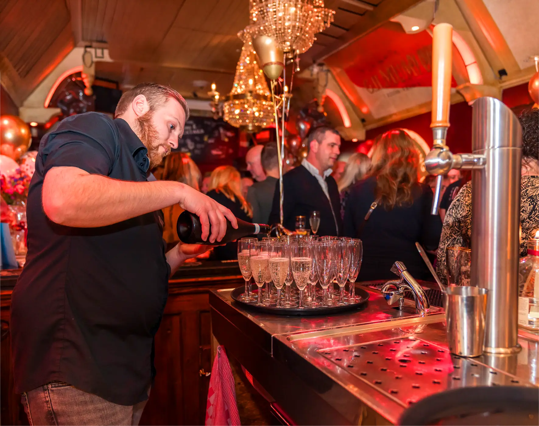 Medewerker schenkt bubbels achter de bar tijdens een feest bij Café de Heeren in Purmerend