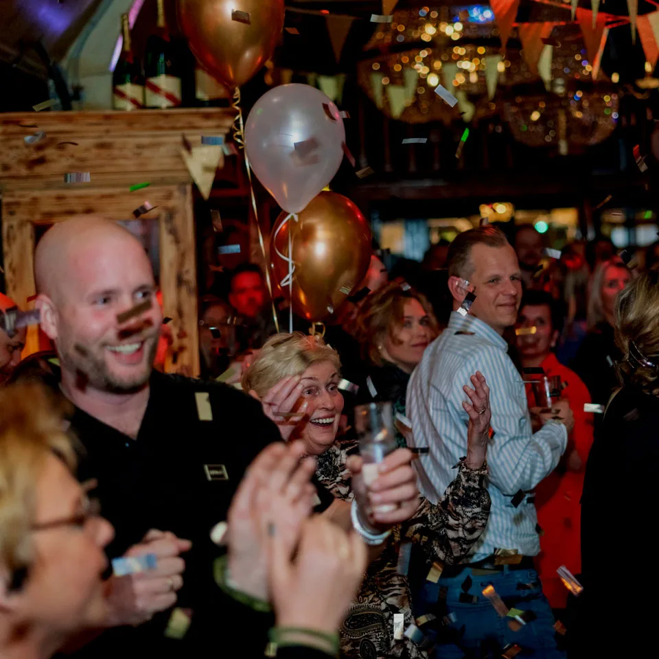 Juichende gasten tussen de confetti tijdens een feest bij Café de Heeren in Purmerend