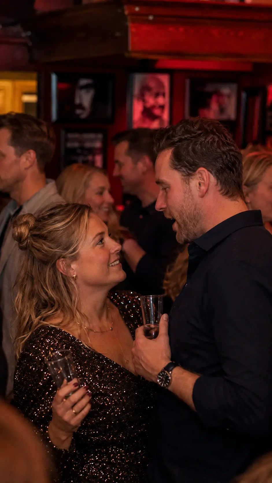 Een stel maakt oogcontact met een drankje tijdens een feest bij Café de Heeren in Purmerend