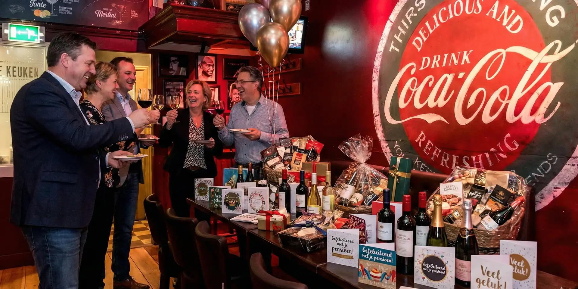 Collega's proosten met cadeaus tijdens een pensioenborrel bij Café de Heeren in Purmerend